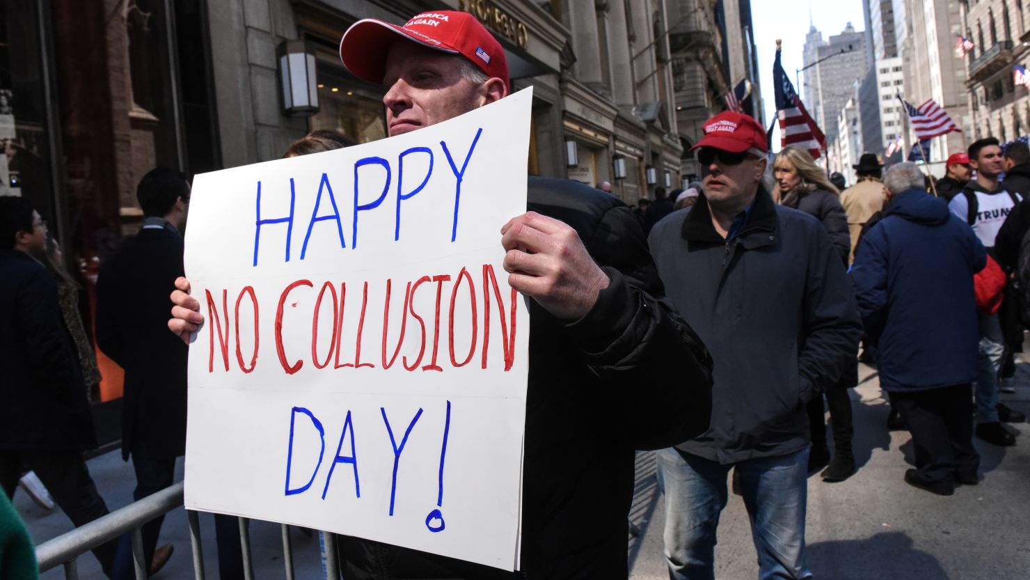 A man holds a sign that reads "Happy No Collusion Day" while people attend a rally in support of President Donald Trump near Trump Tower on March 23, 2019 in New York City. 
