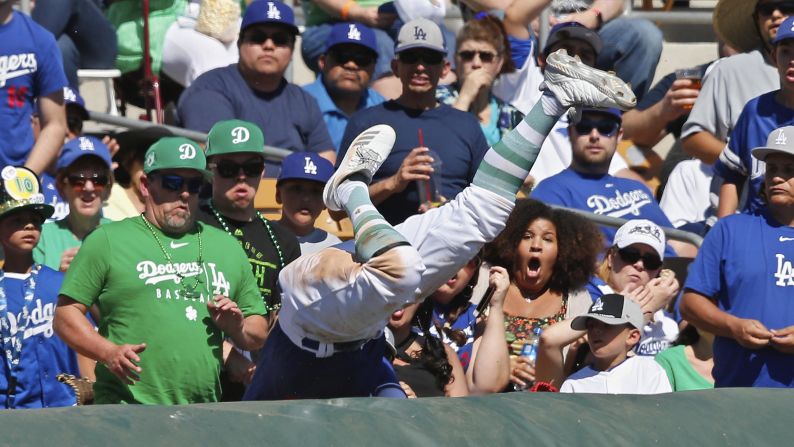 Los Angeles Dodgers third baseman Justin Turner falls into the stands while chasing a foul ball during the third inning of a spring training baseball game against the Milwaukee Brewers in Glendale, Arizona on Sunday, March 17.
