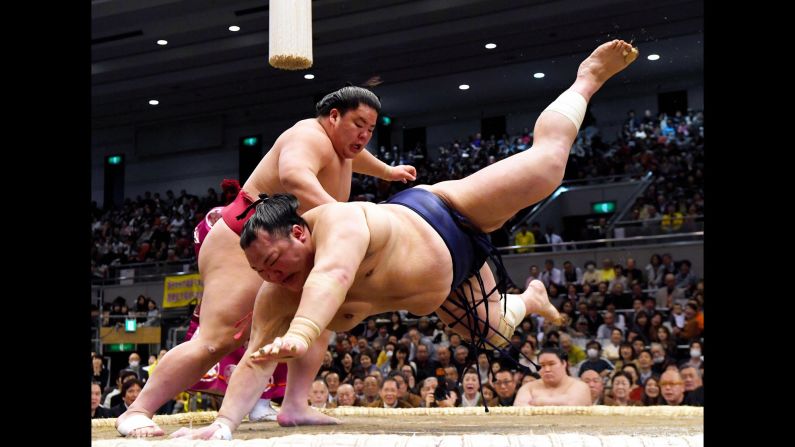 Daieisho Hayato, left, throws Komusubi Hokutofuji to win his match on day 10 of the Grand Sumo Spring Tournament at Edion Arena Osaka in Osaka, Japan on Tuesday, March 19.
