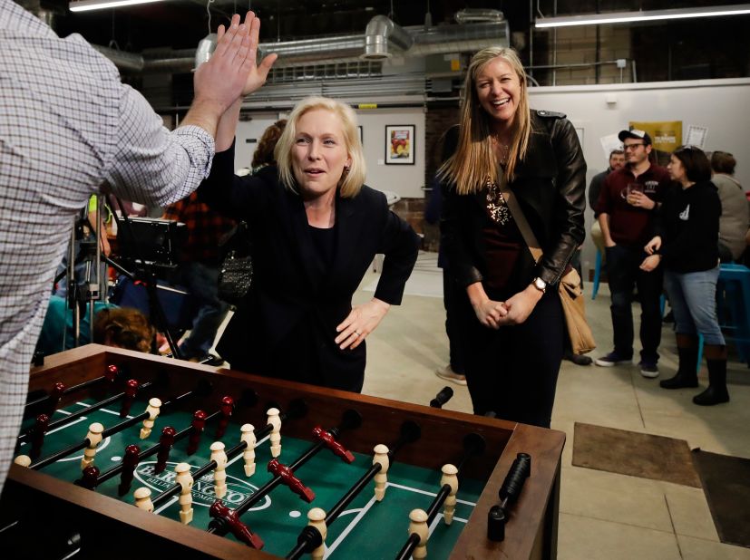 Gillibrand high-fives a foosball opponent while campaigning in Manchester, New Hampshire, in March 2019.