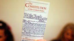 WASHINGTON - JULY 25:  Elementary school teacher Lisa Petry of Virginia Beach, Virginia, holds up a copy of the U.S. Constitution while waiting in line to attend the House Judiciary Committee's hearing on the "Executive Power and Its Constitutional Limitations" at the Rayburn House Office Building on Capitol Hill July 25, 2008 in Washington, DC. Spearheaded by the former Democratic presidential hopeful Kucinich, the hearing included authors, former politicians, university professors and other opponents of the Bush Administration.  (Photo by Chip Somodevilla/Getty Images)