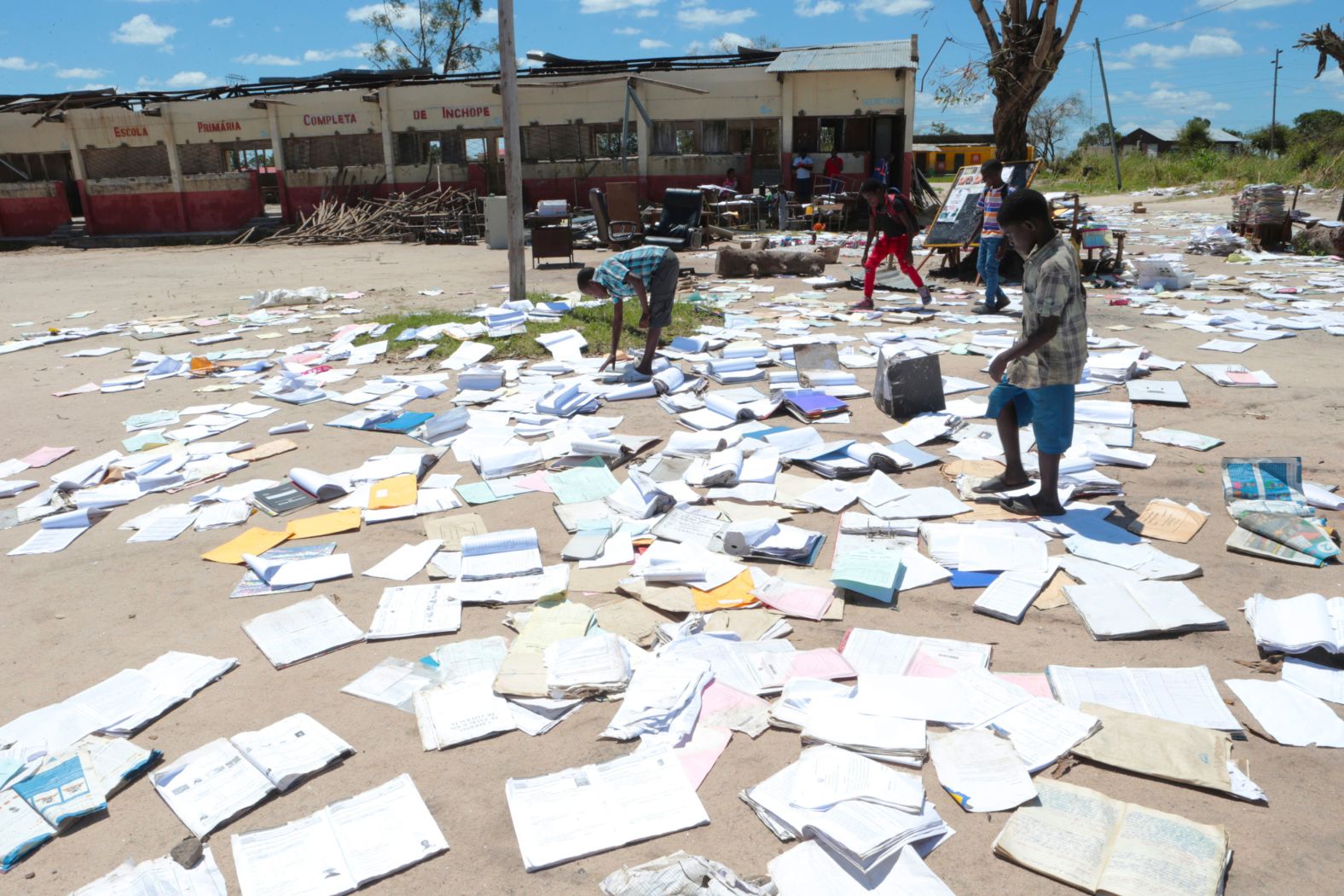 Children pick up books left to dry after Cyclone Idai damaged their school in Inchope, Mozambique, on March 25.