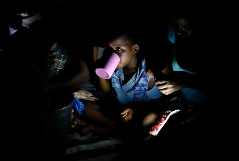 Children eat at a school housing the displaced in Beira, Mozambique, on March 24.