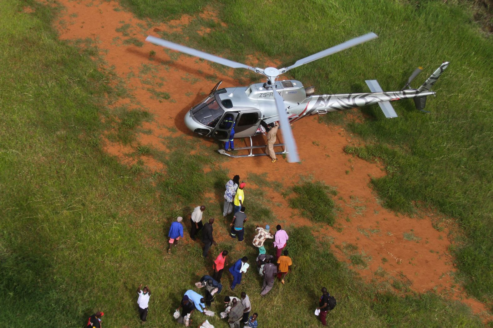 People unload relief supplies from a helicopter in Chimanimani, Zimbabwe, on March 24.