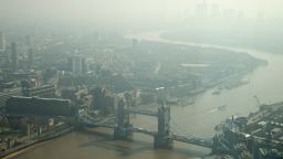 In this general view of London, taken through glass, showing Tower Bridge and looking east towards Canary Wharf, top right, which is just visible through the haze and smog in London, Friday, April 10, 2015. Southern Britain and northern France are suffering high levels of air pollution due to stagnant air, though an Atlantic weather system will bring fresher conditions Saturday, according to weather forecast predictions. (AP Photo/Alastair Grant)