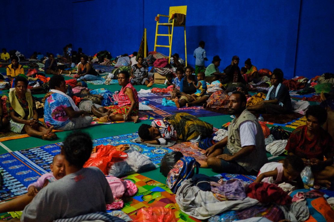 Indonesians displaced by the floods sleep on a badminton court at a local government building in Sentani.