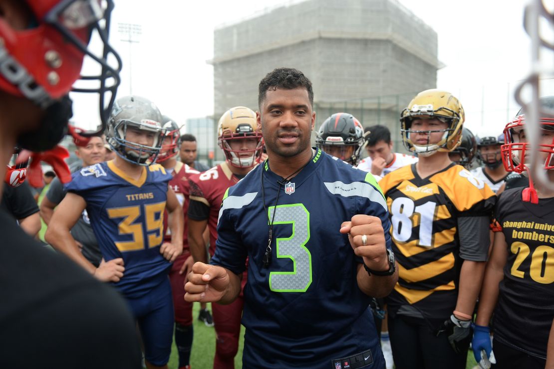 Quarterback Russell Wilson (C) takes part in a training session at a football camp in Shanghai in 2018.