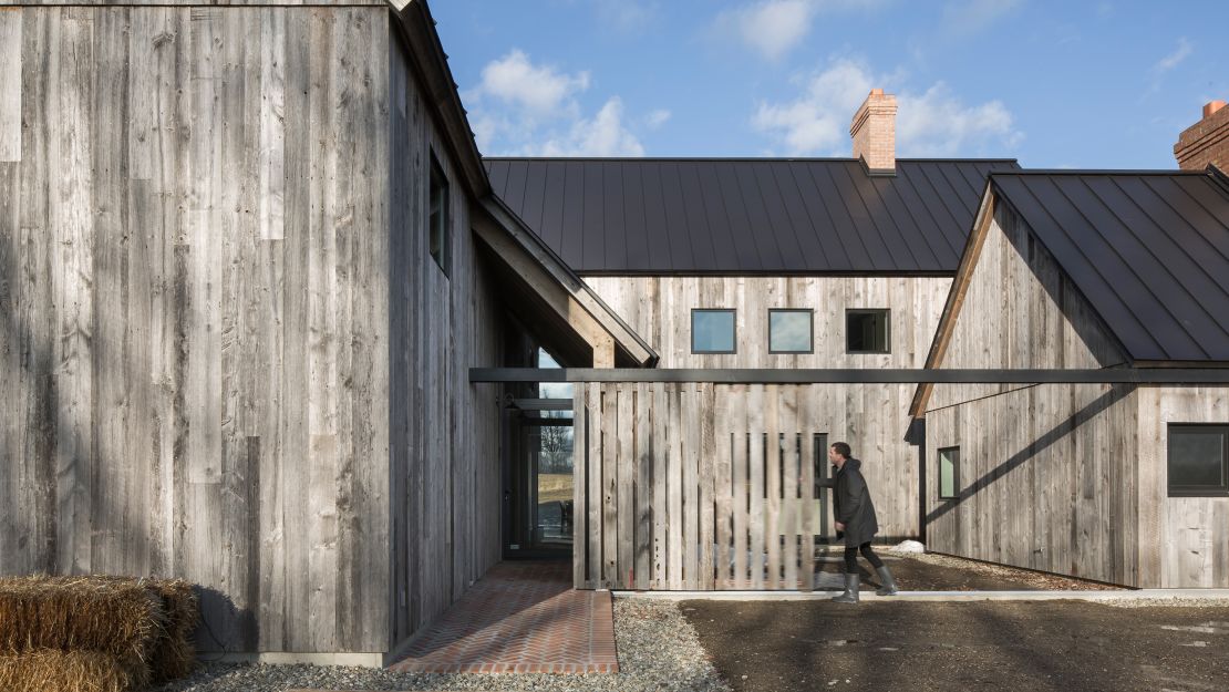 The new construction barn-inspired home features three connected buildings around a courtyard.