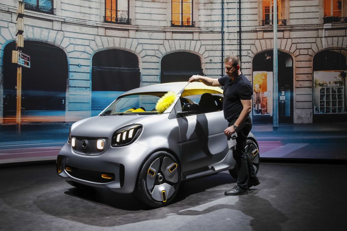 A worker cleans a Smart Forease electric concept at the Geneva Auto Show in March.