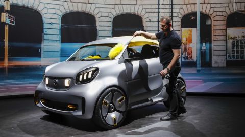 A worker cleans a Smart Forease electric concept at the Geneva Auto Show in March.