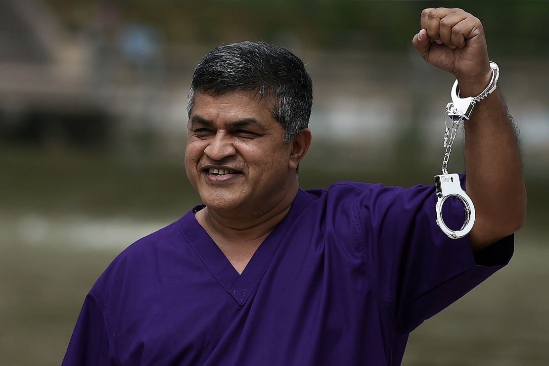 Malaysian cartoonist Zulkifli Anwar Ulhaque, popularly known as Zunar, poses with handcuffs prior to a book-launch event in Kuala Lumpur on February 14, 2015. 