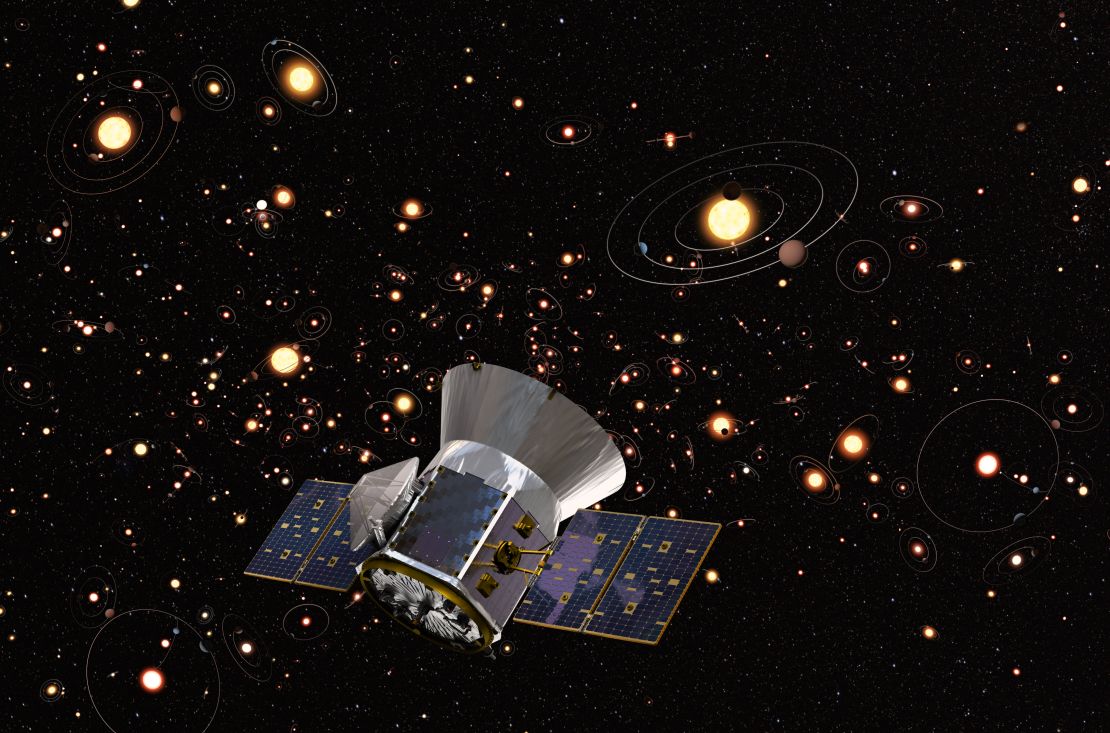 An artist's concept of TESS against a background of stars and orbiting planets in the Milky Way.