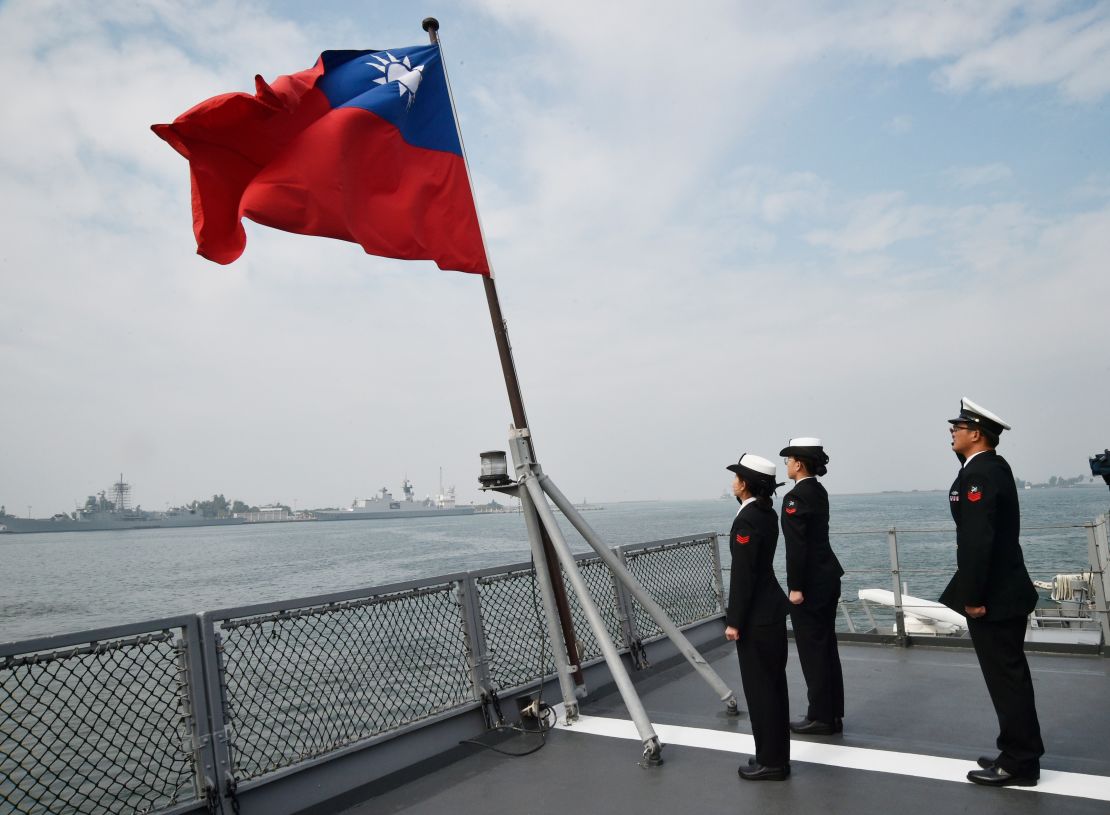 Taiwanese sailors salute the island's flag on the deck of the Panshih supply ship after taking part in live fire drills, at the Tsoying naval base in Kaohsiung on January 31, 2018.
