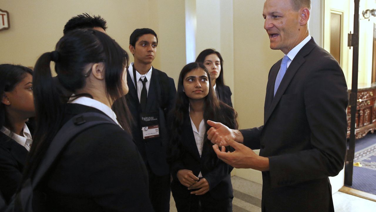 Assemblyman Kevin McCarty, D-Sacramento, right, talks with a group of high school students after his news conference concerning a proposed package of bills dealing with the recent college admissions scandal, Thursday, March 28, 2019, in Sacramento, Calif. McCarty, and other Democratic lawmakers unveiled a half-dozen measures that would require that three college administrators sign off on special admissions and a ban upon preferential admissions for students related to the institution's donors of alumni. (AP Photo/Rich Pedroncelli)