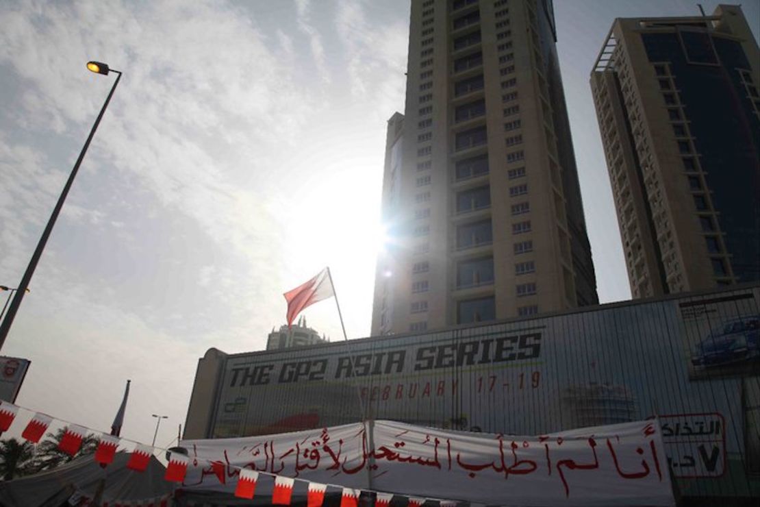 A protest sign is draped over a motorsport advertisement at the now-demolished Pearl Monument in Manama, during the 2011 Arab Spring protests. 