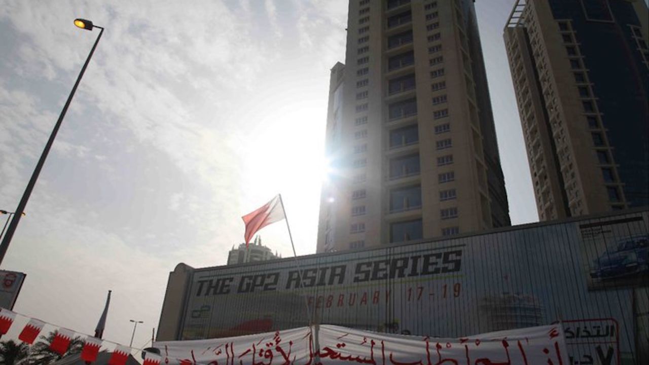 A protest sign is draped over a motorsport advertisement at the now-demolished Pearl Monument in Manama, during the 2011 Arab Spring protests. 