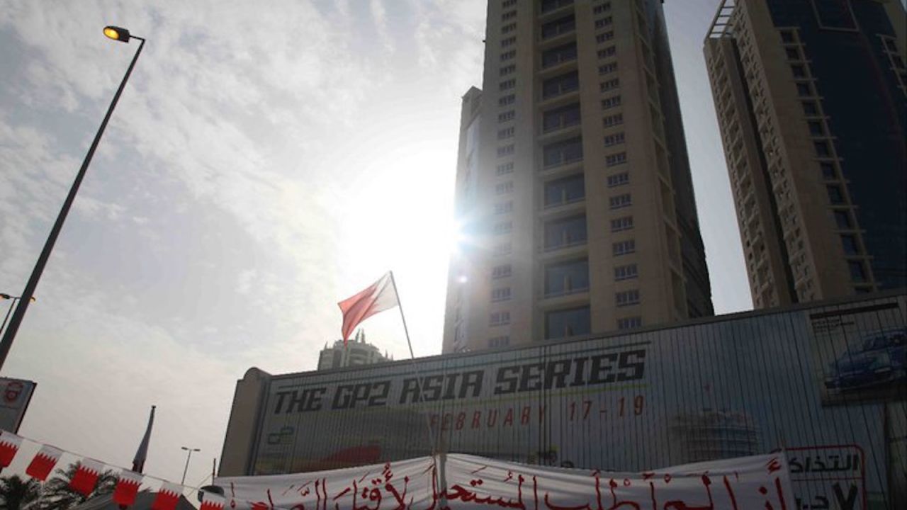 A protest sign is draped over a motorsport advertisement at the now-demolished Pearl Monument in Manama, during the 2011 Arab Spring protests.