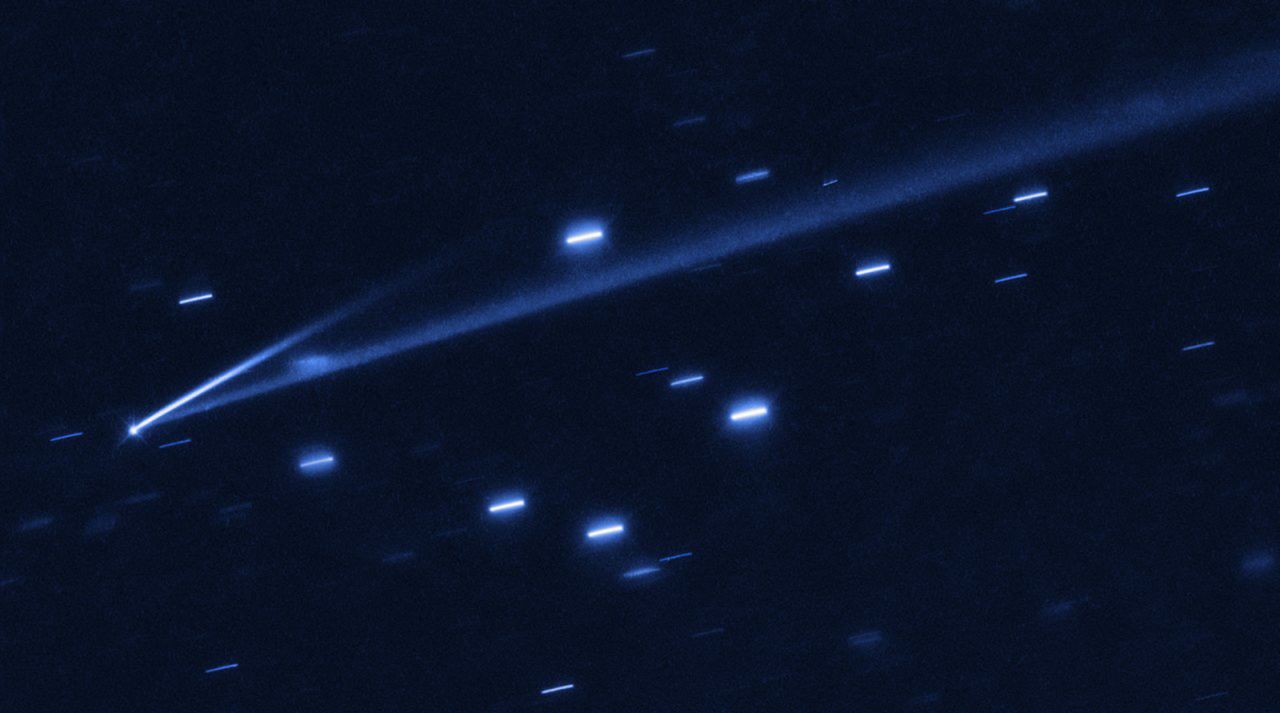 The asteroid 6478 Gault is seen with the NASA/ESA Hubble Space Telescope, showing two narrow, comet-like tails of debris that tell us that the asteroid is slowly undergoing self-destruction. The bright streaks surrounding the asteroid are background stars. The Gault asteroid is located 214 million miles from the Sun, between the orbits of Mars and Jupiter.