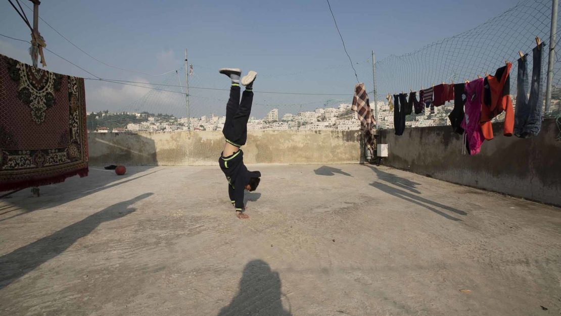 Zein Idris plays on the rooftop of his house in Hebron.