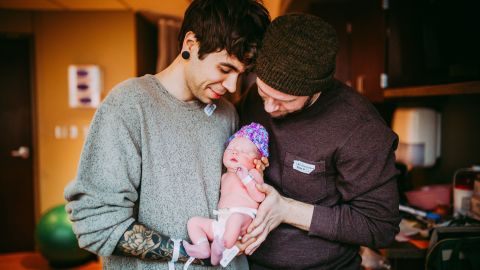 The proud fathers hold their new child. (Ariel Panowicz)