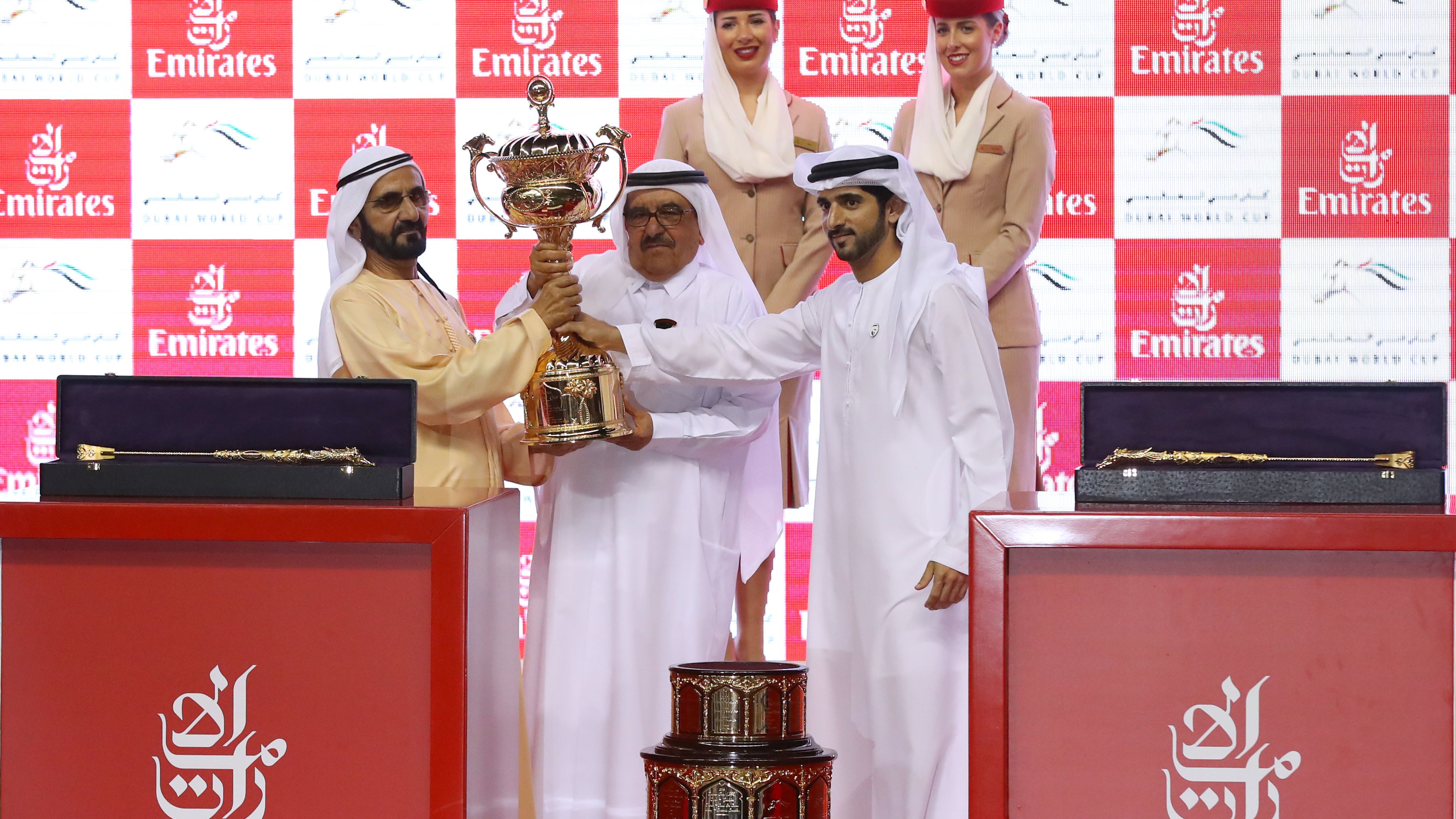 Sheikh Mohammed (L), receives the trophy after his horse Thunder Snow's victory at the Dubai World Cup.