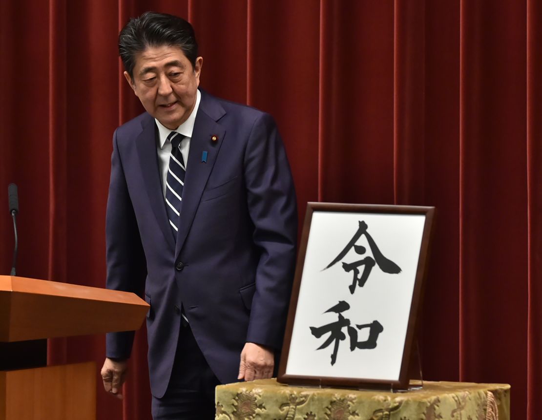 Japan's Prime Minister Shinzo Abe looks at a calligraphy rendering of the new era's name as he leaves a press conference. 