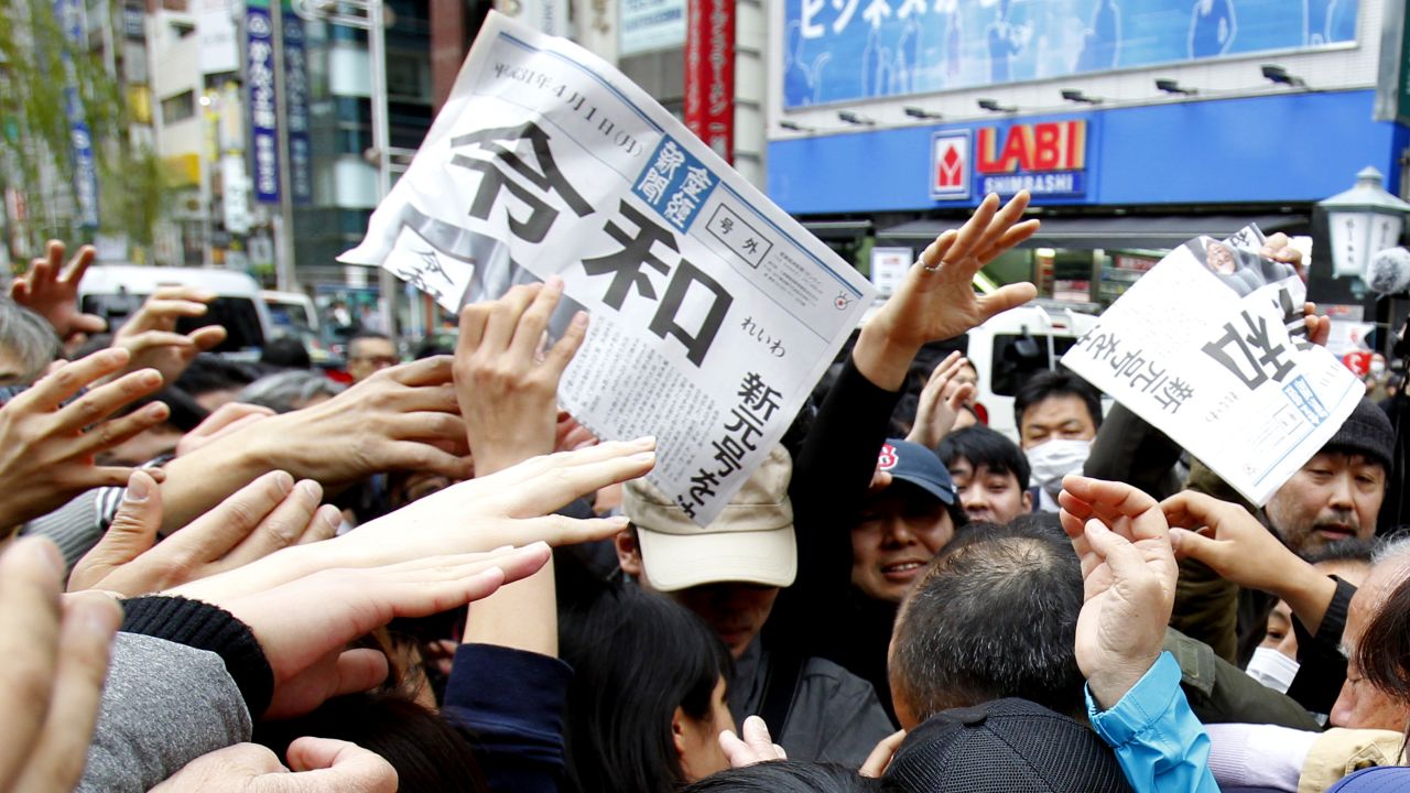 People reach for a copy of extra edition of the Sankei Shimbun newspaper reporting the name of new era.