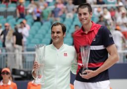 Roger Federer and John Isner pose with their trophies.