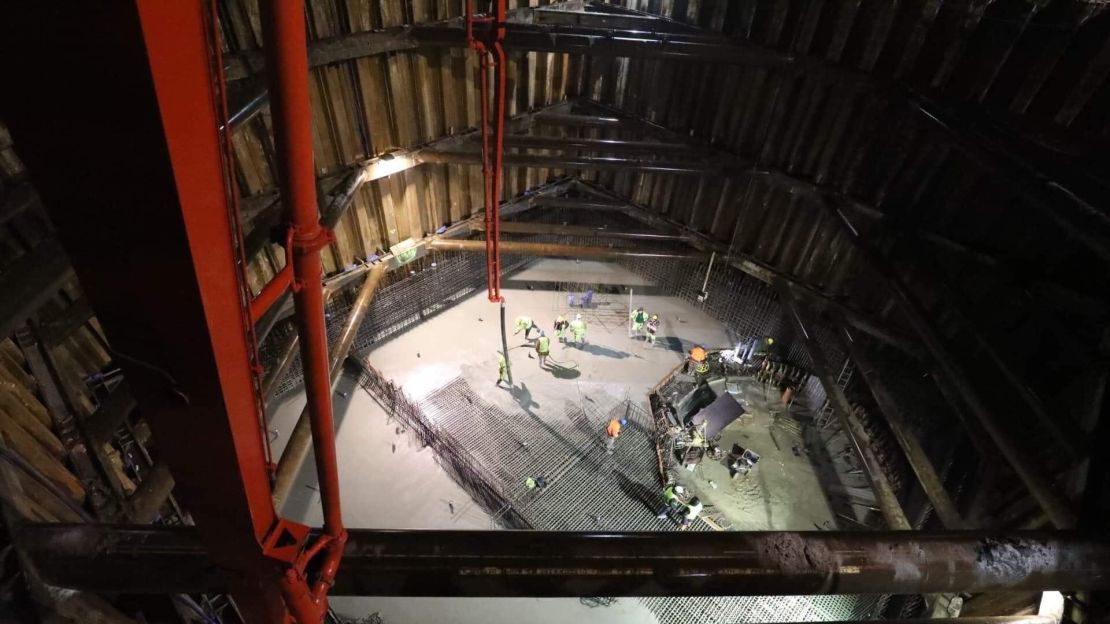 Construction employees at work on the base of the pool.