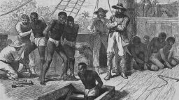 circa 1835:  Slaves aboard a slave ship being shackled  before being put in the hold.  Illustration by Swain  (Photo by Rischgitz/Getty Images)