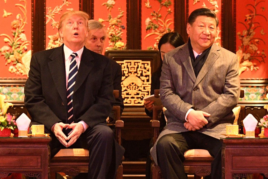 US President Donald Trump  looks up as he sits beside China's President Xi Jinping during a tour of the Forbidden City in Beijing on November 8, 2017. 