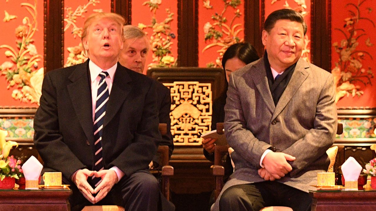 US President Donald Trump looks up as he sits beside China's President Xi Jinping during a tour of the Forbidden City in Beijing on November 8, 2017.