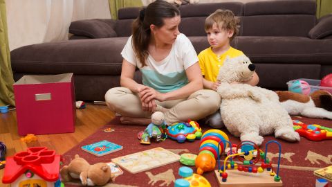 Young pregnant mother and her little son, at home. Mother and little son  sit on a floor. Mom tired to tidy up the house. Child scattered toys. Mess in the house; Shutterstock ID 635755742; Job: -