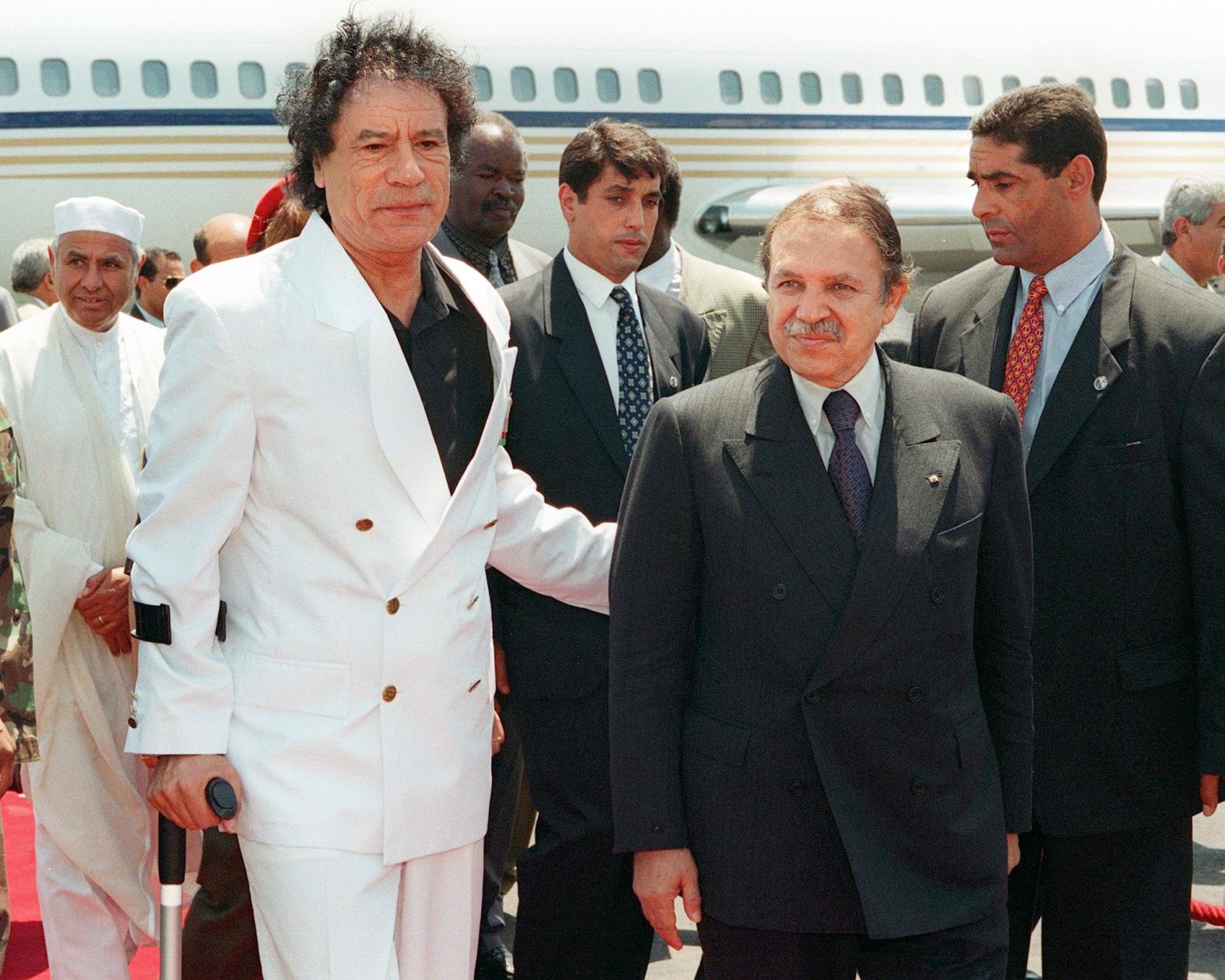 Libyan leader Moammar Gadhafi walks with newly elected President Bouteflika at the Organization of African Unity summit in Algiers in July 1999.