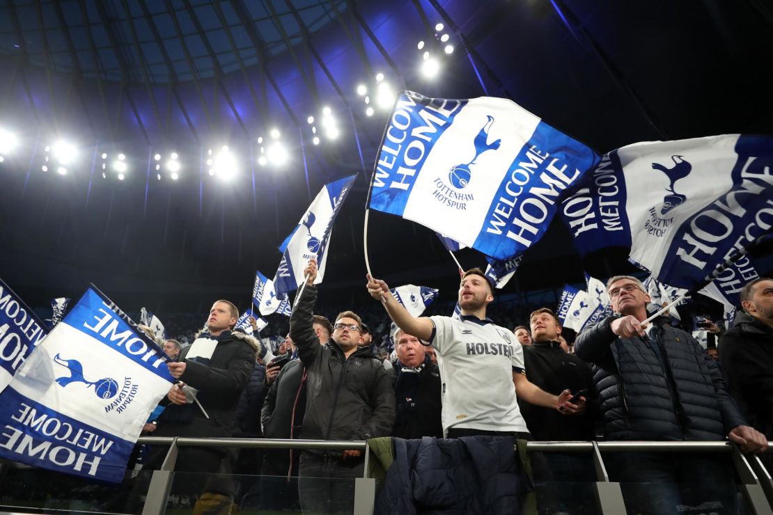 Spurs fans wave flags before the first Premier League game at the  new stadium.