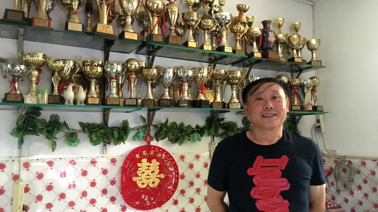 Zhang Jian proudly displays the trophies he has won from pigeon racing