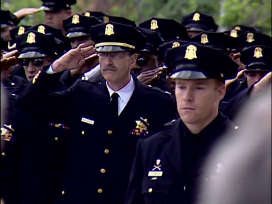 Fellow officers salute at the funeral of Isaac Espinoza, in April 2004.