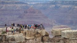 GRAND CANYON NATIONAL PARK, AR - JULY 14:  Visitors stand at the Grand Canyon South Rim on July 14, 2014 at Grand Canyon National Park, Arizona. The Grand Canyon is among the state's biggest tourist destinations.  (Photo by Sean Gallup/Getty Images)