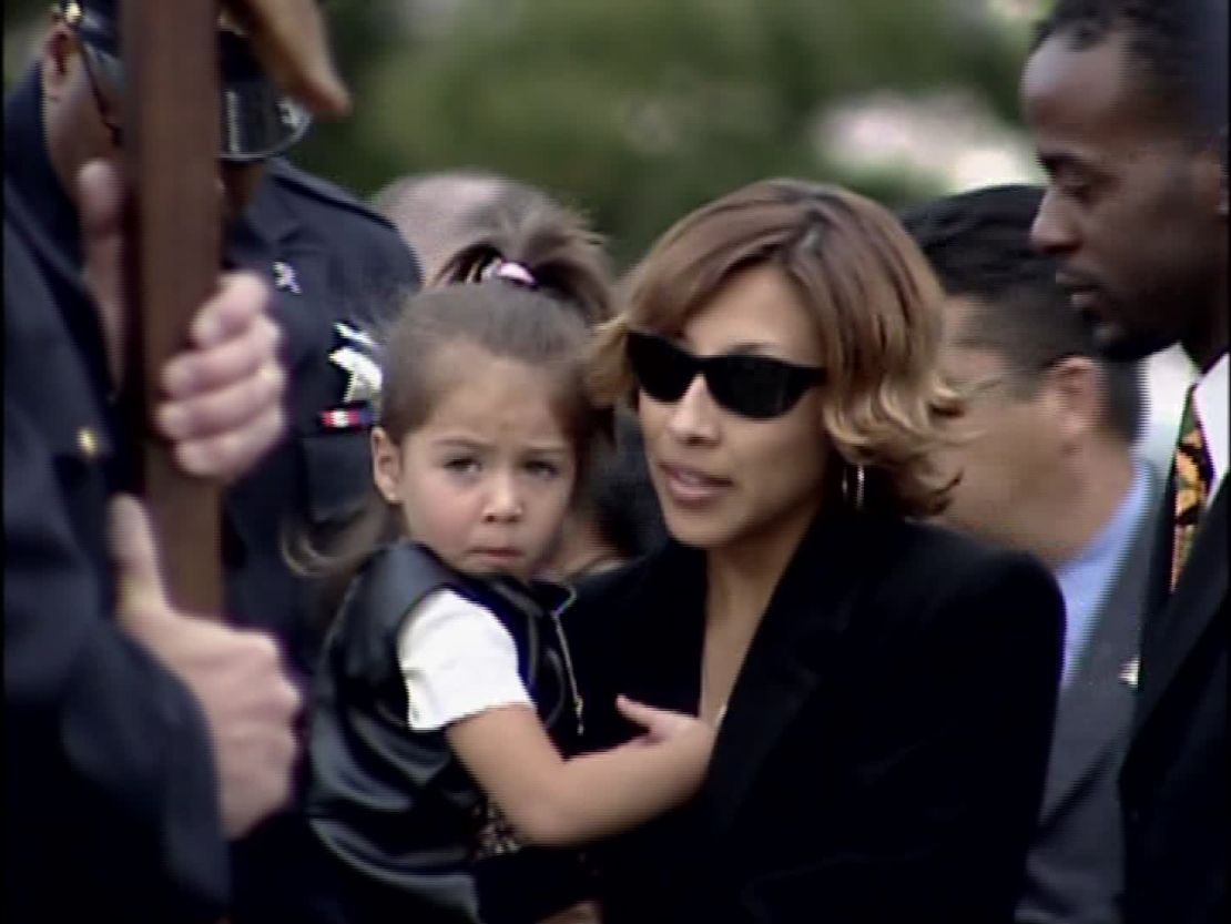 Renata Espinoza holds her daughter at her husband's funeral. 