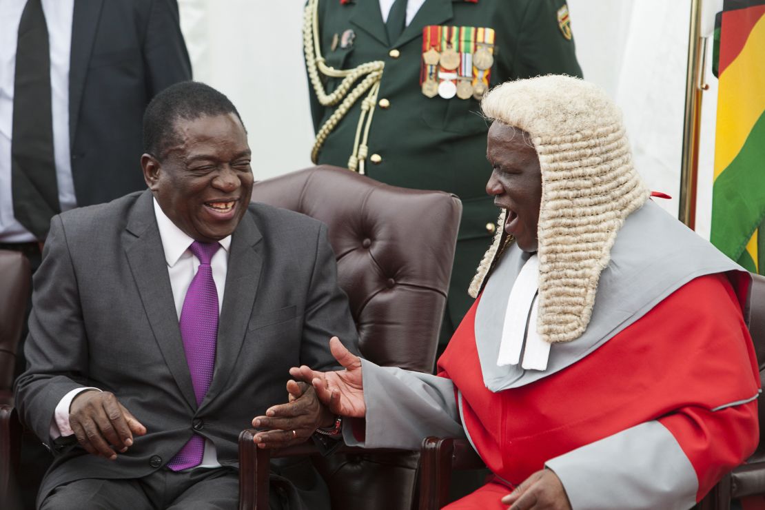 Zimbabwe's President Emmerson Mnangagwa, left, shakes hands with the country's chief justice Luke Malaba.