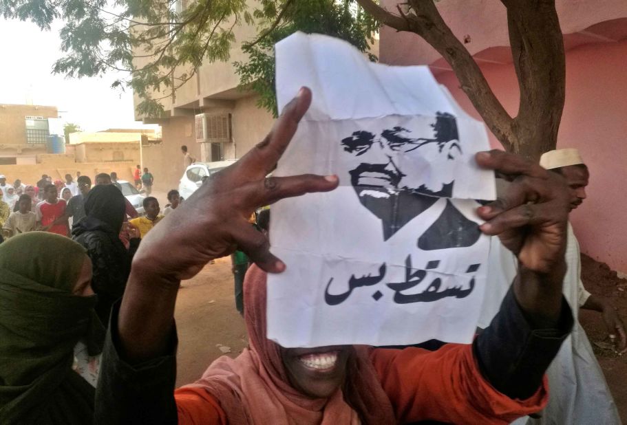 A protester carries a Bashir portrait on February 8. It reads, "Down and that is all."