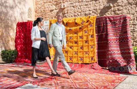 Meghan and Harry walk past tapestries during a visit to Rabat, Morocco, in February 2019.