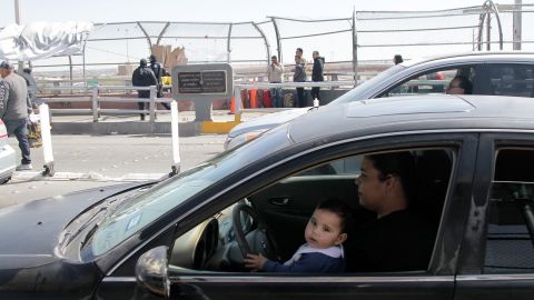 El Paso resident Adriann Romero holds 9-month-old Andres in her lap as they drive across a border crossing to El Paso, Texas. She spent over two hours on the bridge trying to get home after visiting her mother in Ciudad Juarez over the weekend.