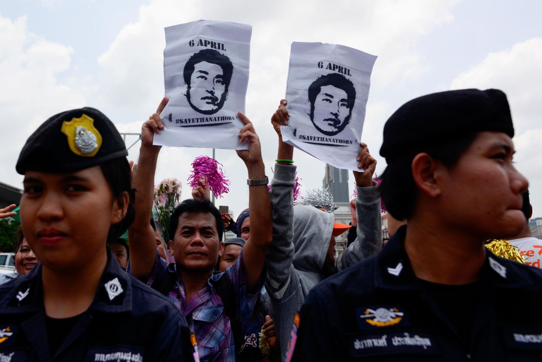 Thanathorn's supporters hold posters bearing his likeness with the hashtag #SaveThanathorn.