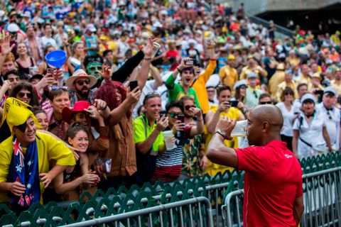 Retired Australian rugby union player George Gregan drinks a beer in front of fans on the second day at the Hong Kong Sevens rugby tournament.