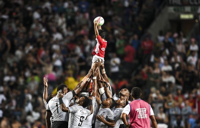 Fiji's team lifts a ball boy in the air before the start of the cup final of the Hong Kong Sevens rugby tournament.