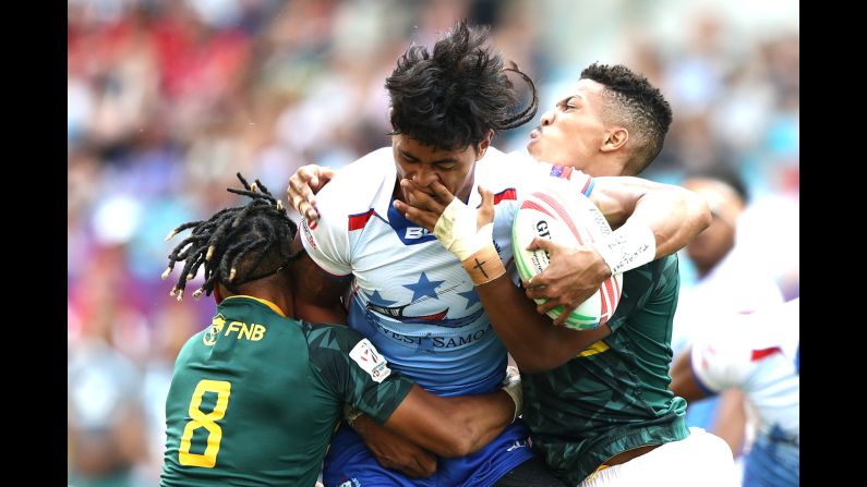 South African players attempt to tackle John Vaili of Samoa during their rugby match on day two of the Hong Kong Rugby Sevens at Hong Kong Stadium on Saturday, April 6.