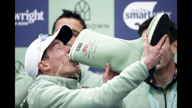Cambridge cox Matthew Holland drinks champagne from a boot after winning the Men's Boat Race on the River Thames, London on Sunday, April 7.