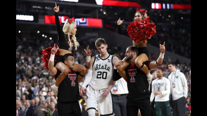 Matt McQuaid of the Michigan State Spartans walks past Texas Tech Red Raiders cheerleaders after losing in their semifinal game in the NCAA Final Four at U.S. Bank Stadium in Minneapolis on Saturday, April 6.
