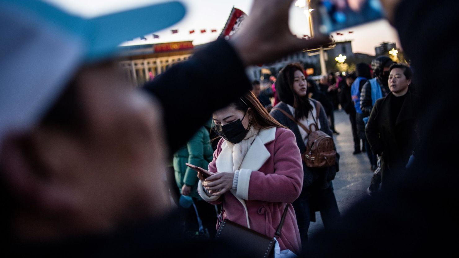 Tourists wait for the daily flag-raising ceremony in Tiananmen Square on March 15, 2019.